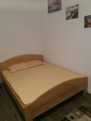a bed in a room with a wooden bed frame at Rooms Adrijana in Banja Luka