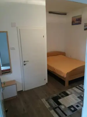 a small bedroom with a bed and a door at Rooms Adrijana in Banja Luka