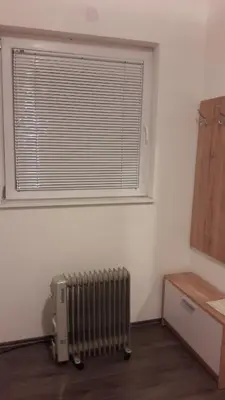 a room with a radiator in front of a window at Rooms Adrijana in Banja Luka