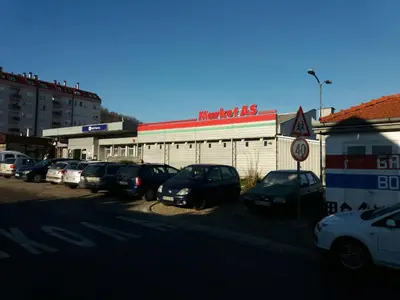 a parking lot with cars parked in front of a building at Rooms Adrijana in Banja Luka