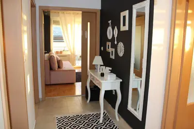 a hallway with a room with a table and a mirror at Apartman Diva in Tuzla