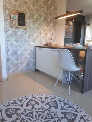 a kitchen with a counter and a white chair at Apartman Diva in Tuzla