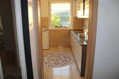 a kitchen with a window and a tile floor at Apartman Diva in Tuzla