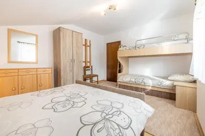 a bedroom with a bed and bunk beds at Apartman Radoš in Kupres