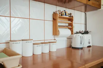 a kitchen counter with a row of white coffee cups at Apartman Radoš in Kupres