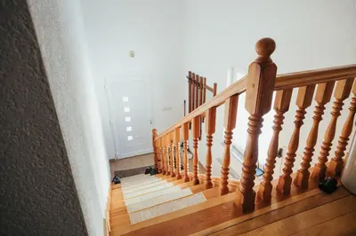 a staircase in a home with a wooden railing at Apartman Radoš in Kupres