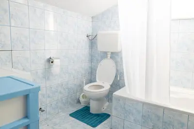 a bathroom with a toilet and a tub and a sink at Apartman Radoš in Kupres