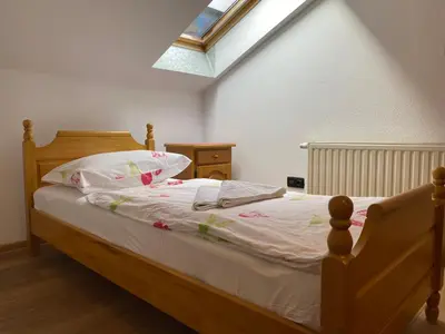 a bedroom with a bed with white sheets and a skylight at Motel Vujeva in Livno