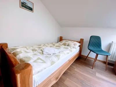 a bedroom with a bed and a blue chair at Motel Vujeva in Livno