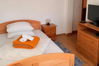 a bedroom with a bed with two towels on it at Gradska Kavana Guest House in Kupres