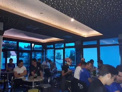 a group of people sitting in a bar at Gradska Kavana Guest House in Kupres