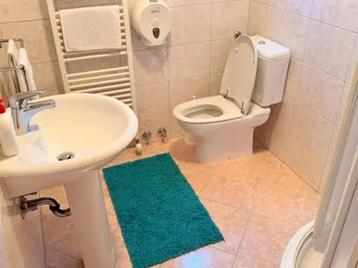 a bathroom with a white toilet and a sink at Gradska Kavana Guest House in Kupres