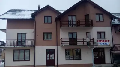 an apartment building with balconies and a sign on it at Guesthouse Nevenko in Kupres