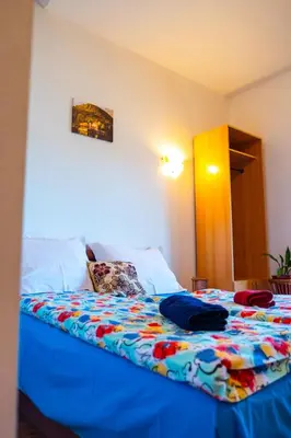 a bed with a colorful blanket on it in a room at Guesthouse Nevenko in Kupres
