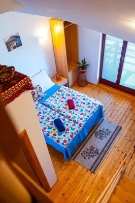 a bedroom with a bed with a blue sheet on it at Guesthouse Nevenko in Kupres