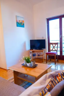 a living room with a coffee table and a tv at Guesthouse Nevenko in Kupres