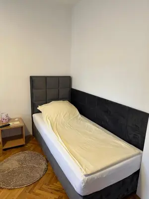 a bed with a black headboard in a room at Una La Unica in Bihać