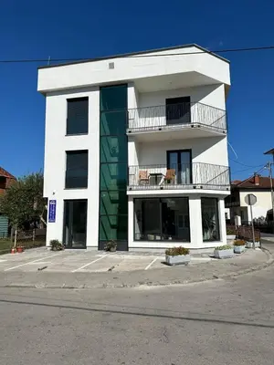a white building with a balcony on a street at Una La Unica in Bihać