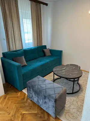 a living room with a blue couch and a table at Una La Unica in Bihać
