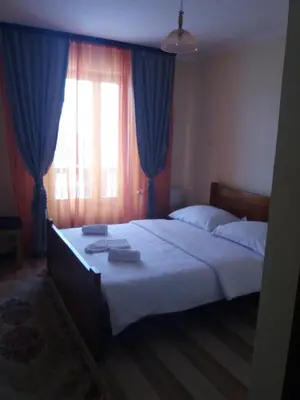 a bedroom with a large bed with blue curtains at Motel Restoran Gurman in Banja Luka