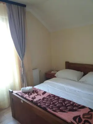 a small bedroom with two beds and a window at Motel Restoran Gurman in Banja Luka