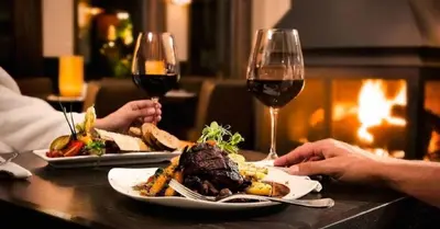 two people sitting at a table with two glasses of wine at Motel Restoran Gurman in Banja Luka