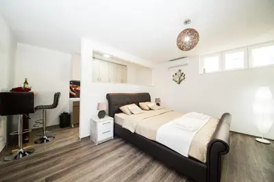 a bedroom with a large bed and a desk at Studio apartman Centar in Banja Luka