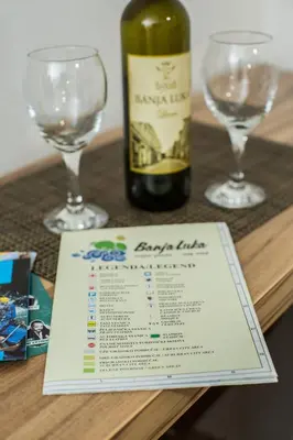 a bottle of wine and two wine glasses on a table at Studio apartman Centar in Banja Luka