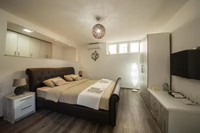 a bedroom with a large bed and a desk at Studio apartman Centar in Banja Luka