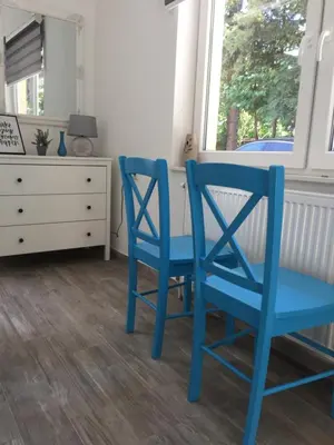 two blue chairs and a table in a room with a window at Apartman Centar in Banja Luka