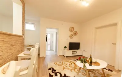 a living room with a table and a tv at Apartman Top Spot in Banja Luka