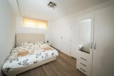 a white bedroom with a bed and a closet at Apartman Top Spot in Banja Luka