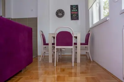 a dining room with purple chairs and a table at Apartman Marija in Banja Luka