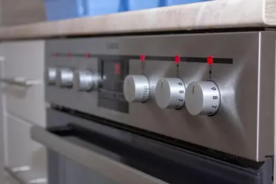 a row of control knobs on a microwave oven at Apartman Marija in Banja Luka