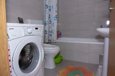 a bathroom with a washing machine and a toilet at Apartman Marija in Banja Luka