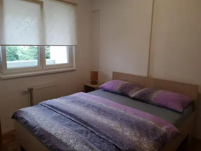 a bedroom with a bed with purple sheets and a window at Apartman Marija in Banja Luka