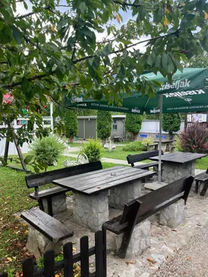 a picnic table and benches in a park at Hotel River View bihac in Lohovo