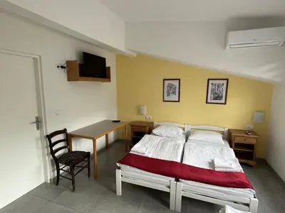 a bedroom with a bed and a table and a desk at Hotel River View bihac in Lohovo