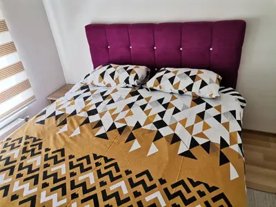 a bedroom with a bed with a purple headboard at Centar Apartman ENMI 111 in Banja Luka