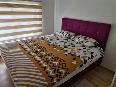 a bed with a purple headboard in a bedroom at Centar Apartman ENMI 111 in Banja Luka