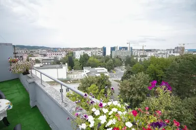a view of a city from a balcony with flowers at Apartman Penthaus u strogom centru Banja Luke in Banja Luka