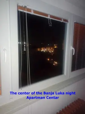 a window with a view of a city at night at Apartman Penthaus u strogom centru Banja Luke in Banja Luka