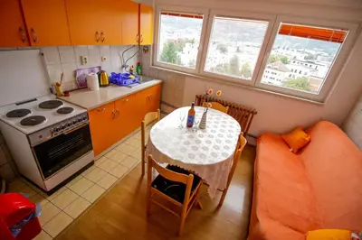 a small kitchen with a table and a couch at Apartman Penthaus u strogom centru Banja Luke in Banja Luka