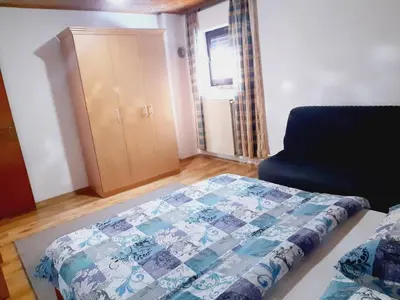 a bedroom with a bed and a chair and a cabinet at Vinara Kupres in Kupres