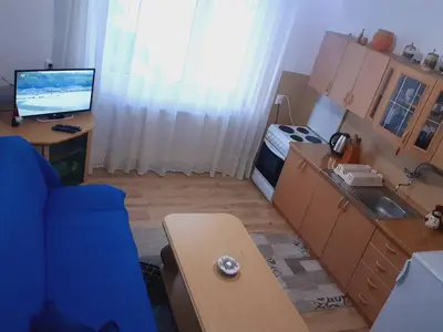 a living room with a blue couch and a kitchen at Vinara Kupres in Kupres