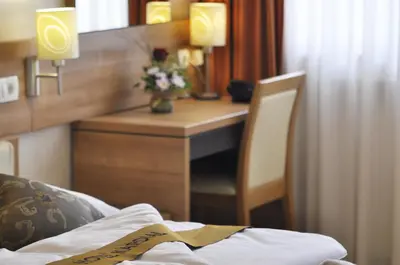 a hotel room with a desk with a bed and a table at Hotel Kardial in Teslić