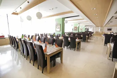a dining room with tables and chairs in a restaurant at Hotel Kardial in Teslić