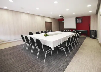 a conference room with a white table and chairs at Hotel Kardial in Teslić