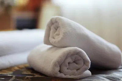 a towel animal sitting on top of a bed at Hotel Kardial in Teslić