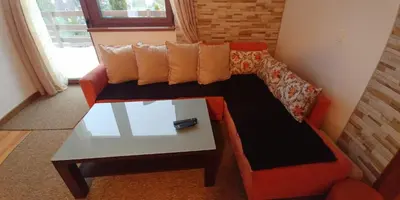 a living room with an orange couch and a coffee table at Lux - Apartment Snow Oasis in Vlasic
